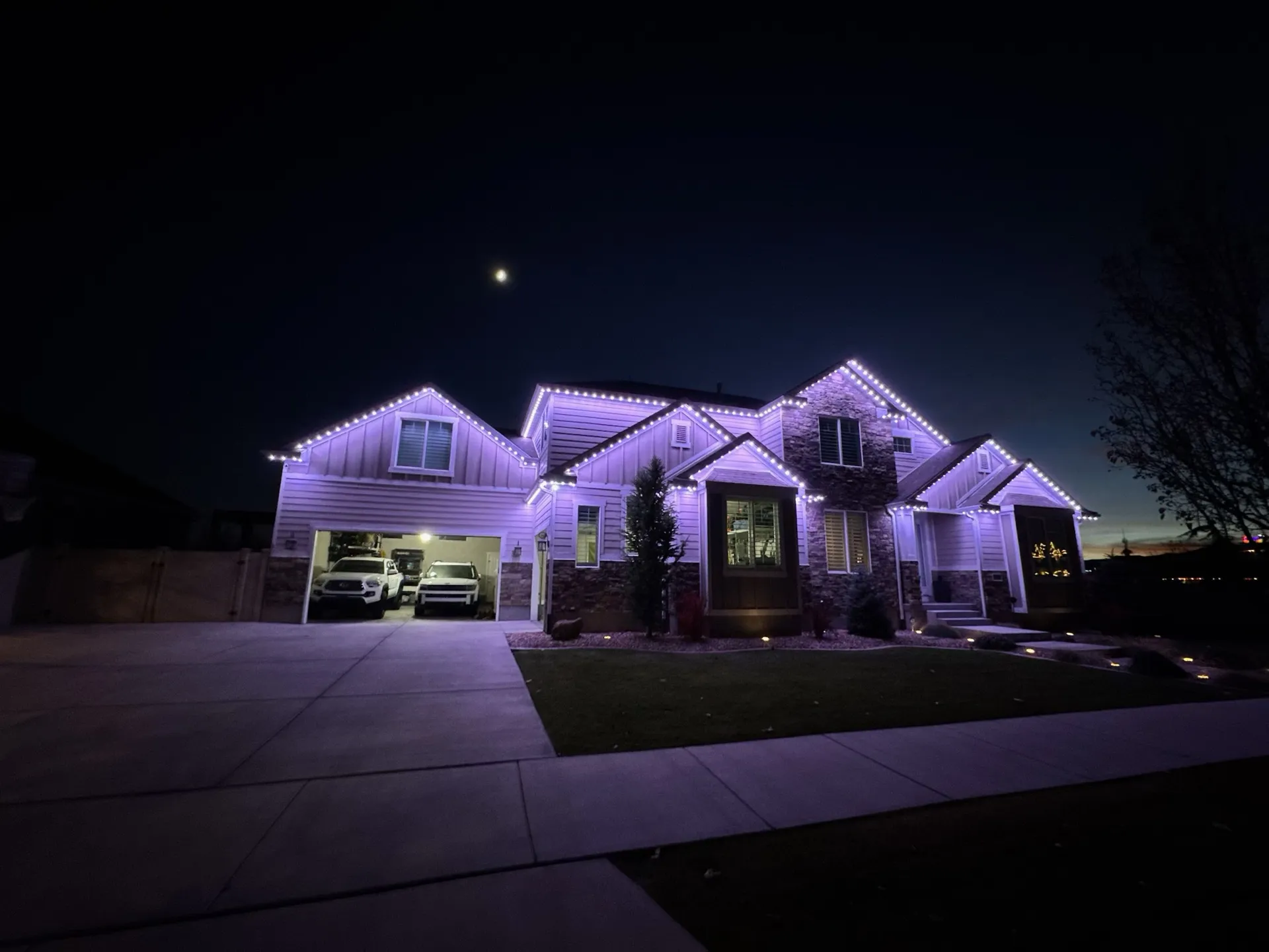 Home exterior at twilight with permanent LED lighting installation